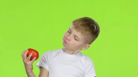 Small boy holding a tomato sniffs it, and shows a thumbs up. Green Screen Vidéo 75788123