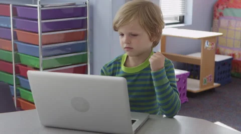 Small boy looking at laptop in classroom - 4K Stock Footage 67336201