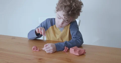 Small boy makes snail out of modelling clay Video stock 128218972