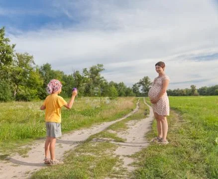 Small boy making soap bubbles with his regnant mother Stock Photos