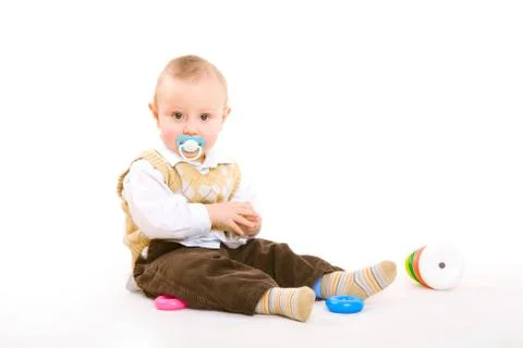Small boy with pacifier plays on the floor Stock Photos