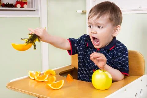 Small boy playing with his fruit Stock Photos