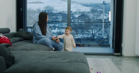 A small boy is playing with his mother in the living room at home. Slow motion. Stock Footage 150873724