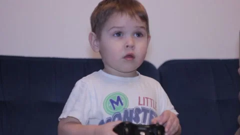 Small boy is playing video game at home 스톡 동영상 148526977