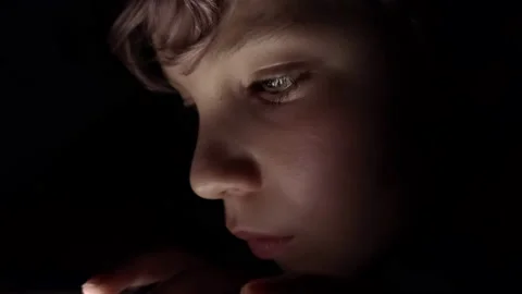 Small boy playing video games in the dark Stock Footage 136908875