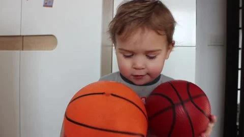 Small boy portrait with two basketball balls in his hands at home Video stock 123072887