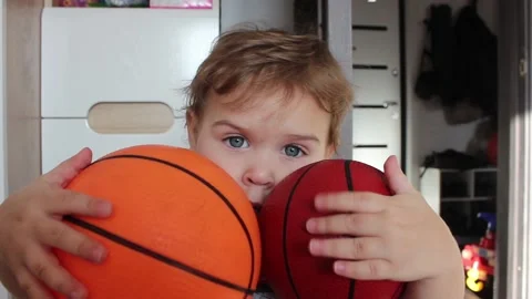 Small boy portrait with two basketball balls in his hands at home Stock Footage 123072891