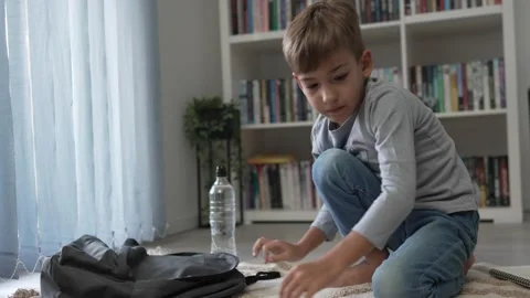 Small boy pupil child prepare his backpack for first day of school Stock Footage 249812251