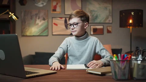 Small boy pupil wearing circle glasses using laptop computer for remote learning Stock Footage 153093140