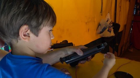 Small boy puts bird shot in gun, Crystal child Stock Footage 79008478