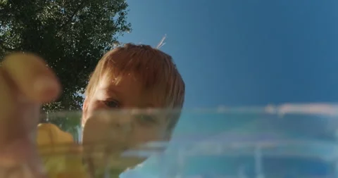 Small boy puts plastic bottles into trash bag in park Stockbeeldmateriaal 167679798