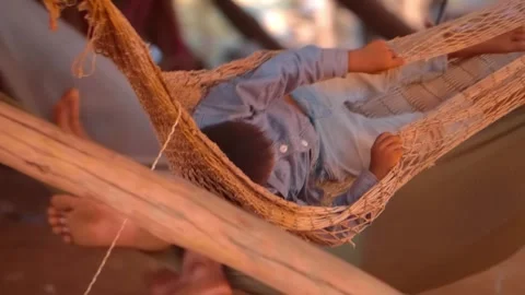 Small boy relaxing and resting in wicker hammocks sways from side to side Stock Footage 305669236