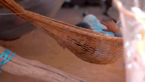 Small boy relaxing and resting in wicker hammocks sways from side to side  Stock Footage 318729123