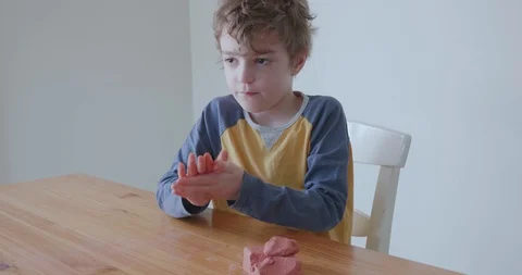 Small boy rolling balls of modeling clay into shape Stock-Footage 128218944