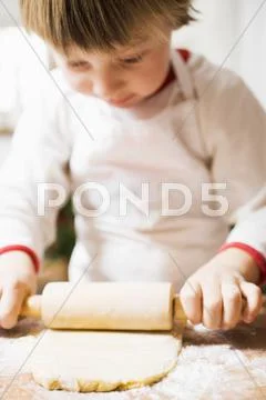 Small boy rolling out pastry Stock Photos