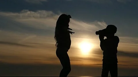Small boy shooting to camera how girl is dancing silhouettes Stock Footage 197565369
