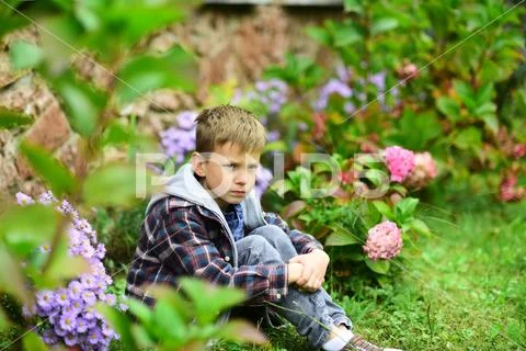 Small boy sit down under insult. Small boy feel deeply insulted. Child abuse and Stock Photos