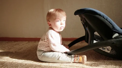 A small boy sits and plays with a cradle Stock Footage 127958176