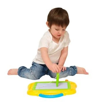 Small boy sitting on floor drawing on magnetic educational toy board. Toddler Stock Photos