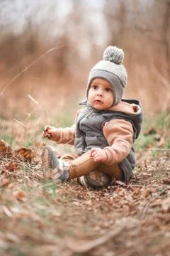 A small boy is sitting on a forest path in a gray jelly Stock Photos