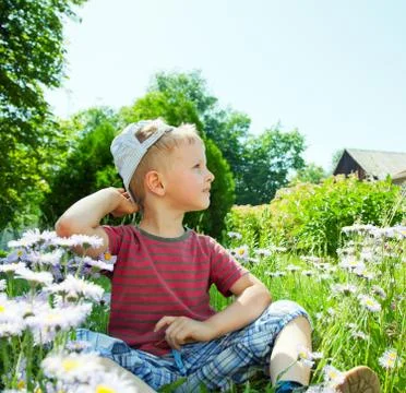 Small boy sitting on the grass Stock Photos