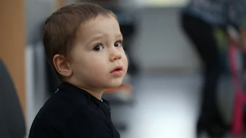 Small boy sitting in the waiting room in hospital Stock Footage