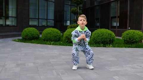 A small boy in a stylish suit dances a HIP-HOP dance on the background Video stock 154687384