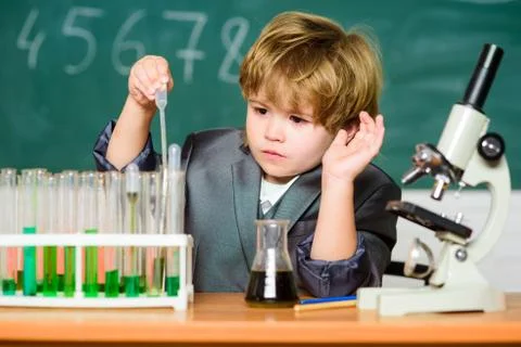 Small boy using microscope at school lesson. result. Medical concept. Little Foto stock