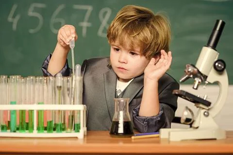 Small boy using microscope at school lesson. result. Medical concept. Little Foto stock
