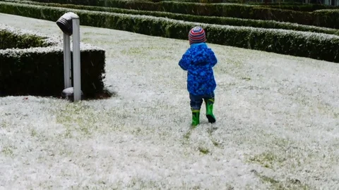 Small boy walking in boots in snow Stock Footage 129518716