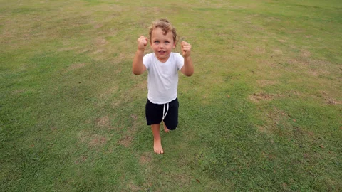 Small boy walking raising small hands, become not capricious but curious 库存影片 322045853