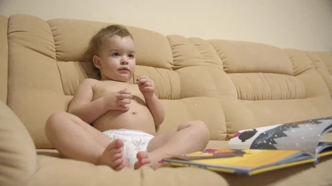A small boy is watching TV sitting on the sofa Video stock 127195684