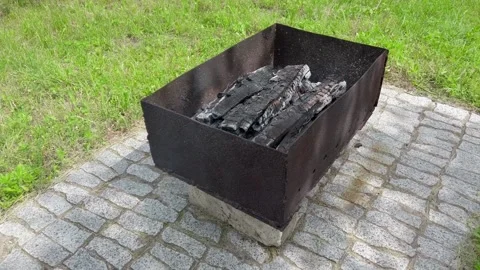 A small brazier filled with burning wood. Cooking on the grill. Meat coocking at Stock Footage 239981780