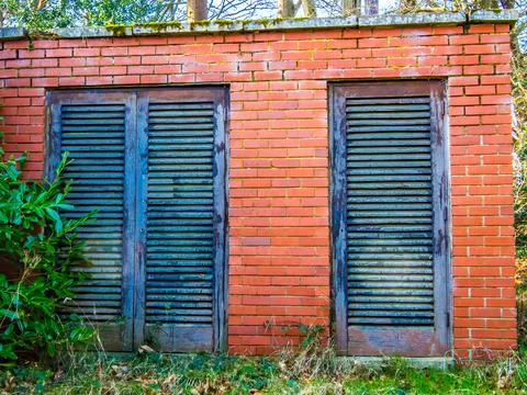 Small brick built utility building with shutters Stock Photos
