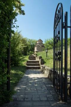 Small brick chapel at the end of the path through an iron gate Foto stock