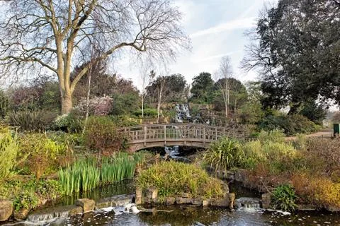 Small bridge over a chanel in a spring park Stock Photos