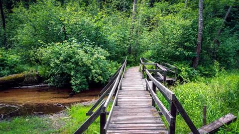 A small bridge over the river with a sandy bottom near the chapel Stock Photos