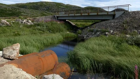A small bridge, a stream and rusty pipes. Stock Footage 84174427