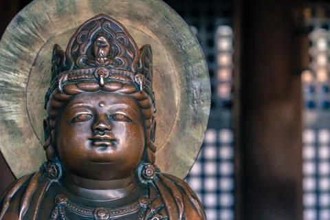 Small bronze Buddha statue with crown on his head in an old Buddhist temple of Stock Photos