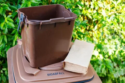 Small brown kitchen compost bin and paper bags for bio-waste on a container w Foto stock