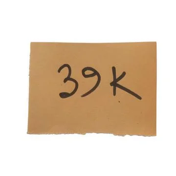 Small brown paper note with the number 39k written in black marker ink Stock Photos