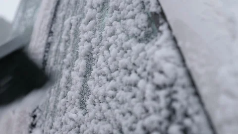 Small brush cleaning a car window covered with ice and snowflakes in Finland Stock-Footage 123088717