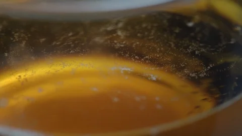 Small bubbles rise inside large glass with yellow beer Video stock 121837767