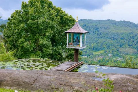 A small Buddha statue set in the middle of a beautiful hilly landscape in s.. Stock Photos