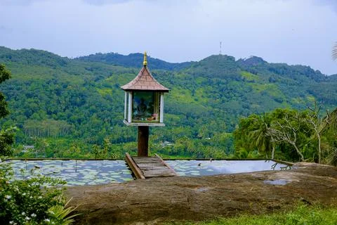 A small Buddha statue set in the middle of a beautiful hilly landscape in s.. Stock Photos
