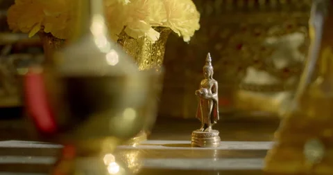 A small Buddha statue stands in the sunlight. Stock Footage 310630933