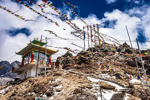 Small buddhist monastery at mountain top with many religious flags at morning Stock-Fotos