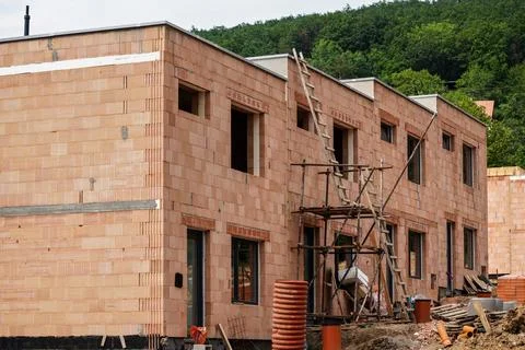 Small building construction site, wall made of orange bricks, small scaffol.. Foto stock
