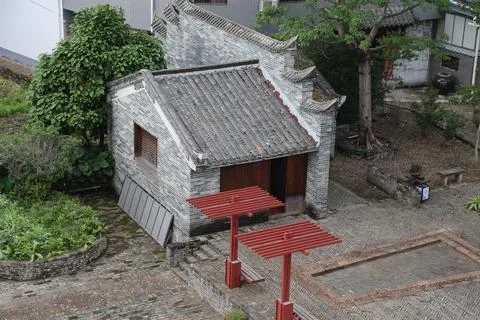 A small building made of gray bricks and tiles, with red steel beams for su.. Foto stock