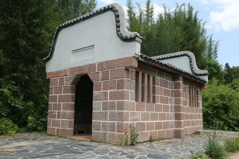 A small building made of red bricks and white walls, with an arched door in.. Stock Photos